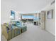Well-lit living room featuring a sofa, chairs, carpeted floors, and sliding glass doors with water views at 1095 Gulf Of Mexico Dr # 503, Longboat Key, FL 34228