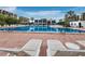 Resort-style pool deck with lounge chairs, tables, and clear blue water at 1095 Gulf Of Mexico Dr # 503, Longboat Key, FL 34228