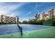 Community tennis court with manicured landscaping and bench seating at 1095 Gulf Of Mexico Dr # 503, Longboat Key, FL 34228