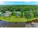 Aerial view of the home, surrounded by mature trees and landscaping, and backing onto a serene lake at 1103 134Th E St, Bradenton, FL 34212