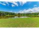 Scenic view of a lush green lawn sloping down to a serene lake reflecting the sky at 1103 134Th E St, Bradenton, FL 34212
