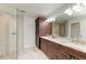 Bathroom featuring dual sinks, dark wood cabinetry, and a glass-enclosed shower at 1103 134Th E St, Bradenton, FL 34212