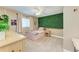 Bright bedroom featuring a unique green accent wall, neutral carpet, and a ceiling fan at 1103 134Th E St, Bradenton, FL 34212