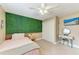 Comfortable bedroom features a green accent wall, ceiling fan, closet, and a wall mounted television at 1103 134Th E St, Bradenton, FL 34212