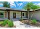 Inviting front porch with stone pathway, decorative columns, and beautifully landscaped greenery at 1103 134Th E St, Bradenton, FL 34212