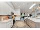Open kitchen featuring white cabinets, stainless appliances, island, and stylish lighting at 1103 134Th E St, Bradenton, FL 34212