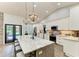 Modern kitchen with white cabinets, marble island, stainless appliances and black framed doors leading to the pool at 1103 134Th E St, Bradenton, FL 34212