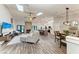 Bright open-concept living room featuring skylights, wood flooring, and a cozy stone fireplace at 1103 134Th E St, Bradenton, FL 34212