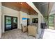 Covered patio features a ceiling fan, television, ample seating and backyard pool access at 1103 134Th E St, Bradenton, FL 34212