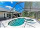 Screened-in pool area with hot tub, outdoor grill, and seating next to backyard at 1103 134Th E St, Bradenton, FL 34212