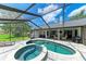 View of sparkling pool and jacuzzi in screened-in patio area with home access at 1103 134Th E St, Bradenton, FL 34212