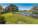 Spacious backyard with a serene lake view and lush green lawn at 12005 Summer Meadow Dr, Lakewood Ranch, FL 34202