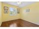Bedroom features a window with blinds, wood floors, and neutral wall paint at 12005 Summer Meadow Dr, Lakewood Ranch, FL 34202