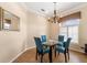 Cozy dining room with neutral walls, chandelier and dining table with four blue chairs at 12005 Summer Meadow Dr, Lakewood Ranch, FL 34202