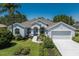 Charming single-story home featuring an attached two-car garage, manicured landscaping, and a well-maintained lawn at 12005 Summer Meadow Dr, Lakewood Ranch, FL 34202