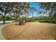 A fun community playground with a slide and climbing equipment surrounded by lush green landscaping and shade trees at 12005 Summer Meadow Dr, Lakewood Ranch, FL 34202