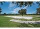 Sand volleyball court with a net, set in a community park with manicured lawns and trees for shade at 12005 Summer Meadow Dr, Lakewood Ranch, FL 34202