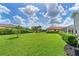 Large backyard with well-maintained lawn and mature trees, and a screened patio, providing a serene outdoor space at 15451 27Th E Ct, Parrish, FL 34219