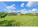 Expansive backyard with lush lawn, mature trees, and enclosed patio, perfect for outdoor activities at 15451 27Th E Ct, Parrish, FL 34219