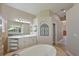Elegant primary bathroom featuring a large soaking tub, dual vanities, and linen storage at 15451 27Th E Ct, Parrish, FL 34219