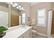 Bathroom with quartz vanity top, large mirror, walk-in shower with tile surround, and tiled floors at 15451 27Th E Ct, Parrish, FL 34219