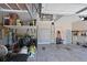 Well-organized garage with overhead storage racks, cabinets, and access door at 15451 27Th E Ct, Parrish, FL 34219