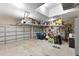 A spacious three-car garage with ample storage provided by overhead shelving at 15451 27Th E Ct, Parrish, FL 34219