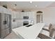 Bright kitchen features stainless steel appliances, white cabinets, and a spacious quartz countertop with bar seating at 15451 27Th E Ct, Parrish, FL 34219