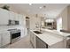 Open kitchen with stainless appliances, white cabinetry, a subway tile backsplash, and breakfast bar seating with an open concept at 15451 27Th E Ct, Parrish, FL 34219