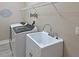 Laundry room features a utility sink, washer and dryer hookups, and wire shelving for storage at 15451 27Th E Ct, Parrish, FL 34219