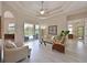 Spacious living room with lots of seating, ceiling fan and direct access to the screened in pool at 15451 27Th E Ct, Parrish, FL 34219
