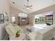 Bright living room showcasing a vaulted ceiling, a ceiling fan, and sliders leading to a screened lanai and pool at 15451 27Th E Ct, Parrish, FL 34219