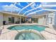 Private screened-in pool area with brick patio, spa, and outdoor seating at 15451 27Th E Ct, Parrish, FL 34219