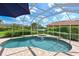 Inviting screened-in pool and spa with lush greenery and a view of the lake at 15451 27Th E Ct, Parrish, FL 34219