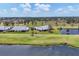 Scenic aerial view of a well-maintained lawn, single story home, and large pond and additional homes at 1714 Fairway Trce, Palmetto, FL 34221