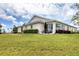 Back exterior view of home showcasing patio, backyard, and lush landscaping at 1714 Fairway Trce, Palmetto, FL 34221
