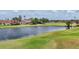 Picturesque view of a tranquil pond and golf course surrounded by lush green grass and mature trees at 1714 Fairway Trce, Palmetto, FL 34221