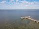 Stunning aerial view of a wooden pier extending into a tranquil body of water, surrounded by a serene landscape at 1714 Fairway Trce, Palmetto, FL 34221