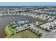 Aerial view of a lakeside community featuring luxurious homes and a community pool with tennis courts at 17902 Cherished Loop, Lakewood Ranch, FL 34211