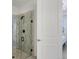 Clean bathroom featuring a glass shower with black hardware and a white door at 17902 Cherished Loop, Lakewood Ranch, FL 34211