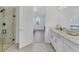 Bright bathroom featuring double vanities, a walk-in shower, and views of the bedroom at 17902 Cherished Loop, Lakewood Ranch, FL 34211