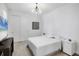 Calm bedroom with white walls, white bedding, a TV, and minimalist decor at 17902 Cherished Loop, Lakewood Ranch, FL 34211