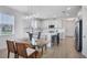 Open-concept dining area with modern lighting and views of the kitchen's quartz countertops, stainless appliances, and island at 17902 Cherished Loop, Lakewood Ranch, FL 34211