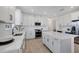 Modern kitchen boasting white cabinets, stainless steel appliances, quartz countertops, and a center island with seating at 17902 Cherished Loop, Lakewood Ranch, FL 34211