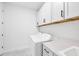 A well-lit laundry room with white cabinets, modern appliances, and a sleek countertop and sink at 17902 Cherished Loop, Lakewood Ranch, FL 34211