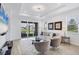 Bright living room with tray ceilings, modern lighting, plush seating, and sliding glass doors to the outside at 17902 Cherished Loop, Lakewood Ranch, FL 34211