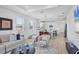 Inviting living room with contemporary decor, large windows, and an open layout flowing into the kitchen and dining spaces at 17902 Cherished Loop, Lakewood Ranch, FL 34211