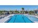 Community pool with lounge seating, umbrellas, and palm trees creates a relaxing oasis at 17902 Cherished Loop, Lakewood Ranch, FL 34211
