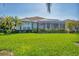 Back exterior of home features well-kept landscaping, a screened-in lanai, and beautiful sunlight at 1806 85Th Nw Ct, Bradenton, FL 34209