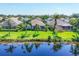Back exterior view showing a screened in porch, lush green lawn, and a peaceful pond at 1806 85Th Nw Ct, Bradenton, FL 34209